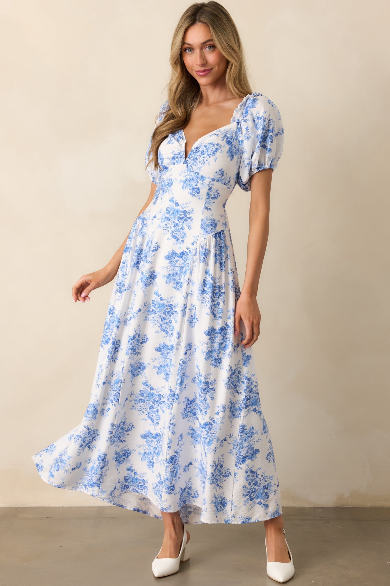 Blue floral maxi dress highlighting the intricate panel design, ruffle accents, and soft movement of the drop waist silhouette.