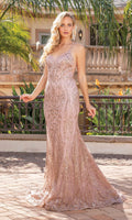 A woman stands outdoors by a railing, wearing the Long Glitter Mermaid Formal Prom Dress 4337—a sleeveless, light pink, floor-length gown—with plants and a building in the background.
